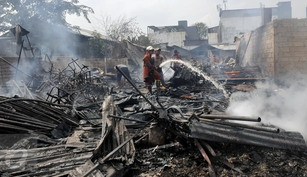 Petugas pemadam dibantu warga memadamkan bara api yang masih tersisa di puing-puing rumah di Jalan Gotong Royong, RW 002 Pondok Bambu, Jakarta, Senin (8/8). Tiga orang terluka dalam kebakaran yang menghanguskan 90 rumah itu. (Liputan6.com/Johan Tallo)