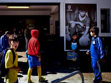 Pesepak bola muda berdiri di depan foto Cristiano Ronaldo saat masih bermain di CF Andorinha ketika berusia 7-9 tahun di Funchal, Madeira, Portugal, (30/4/2016). (AFP/Patricia De Melo Moreira)