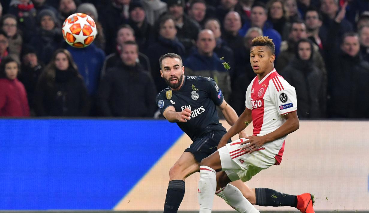 Dani Carvajal mencoba melepaskan umpan pada leg 1, 16 besar Liga Champions yang berlangsung di stadion Amsterdam Arena, Amsterdam, Kamis (14/2). Real Madrid menang 2-1 atas Ajax. (AFP/Emmanuel Dunand)