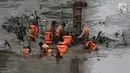 Sejumlah pasukan oranye berjibaku membersihkan sampah batang kayu dan bambu yang tersangkut di aliran sungai Ciliwung di kawasan Sudirman, Jakarta, Jumat (9/2). (Liputan6.com/Faizal Fanani)