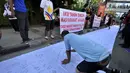 Seorang warga membubuhkan tanda tangan mendukung pemakzulan Gubernur DKI Basuki Tjahaja Purnama alias Ahok di Bundaran HI, Jakarta, Minggu (22/2/2015). Mereka melakukan aksi ini karena kebijakan Ahok dinilai tak pro-rakyat. (Liputan6.com/Faizal Fanani)