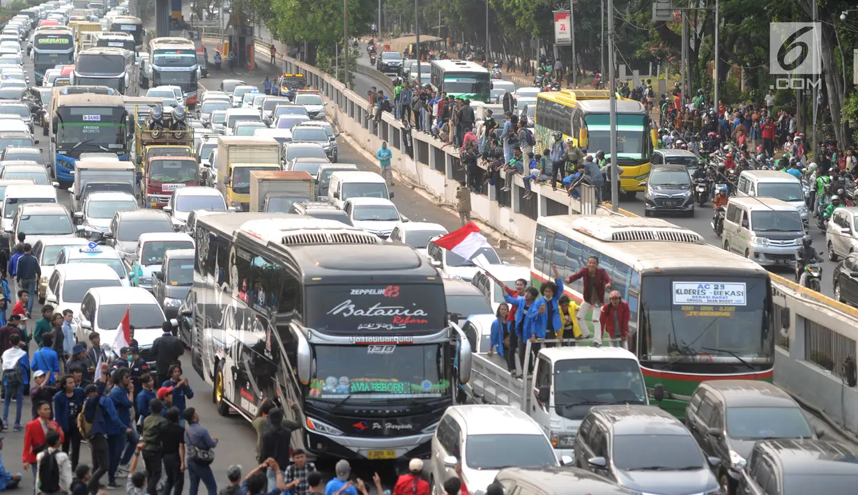 Kendaraan terjebak kemacetan saat mahasiswa memblokade Tol Dalam Kota dalam demonstrasi menolak RUU KUHP dan revisi UU KPK di depan Gedung DPR, Jakarta, Selasa (24/9/2019). Selain memblokade arus kendaraan, mahasiswa juga melakukan bakar-bakaran di Tol Dalam Kota. (merdeka.com/Arie Basuki)