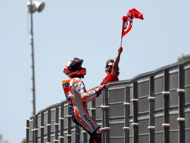 Pembalap Repsol Honda, Marc Marquez memanjat pagar lintasan setelah berhasil finis pertama pada balapan MotoGP Spanyol 2018 di Sirkuit Jerez, Minggu (6/5). Marquez mengukir waktu 41 menit 39,678 detik. (AP Photo/Miguel Morenatti)