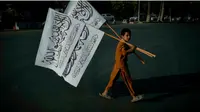 Seorang anak laki-laki membawa bendera Taliban untuk dijual di ibu kota Afghanistan Kabul Hoshang Hashimi. (AFP)