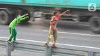 Anak-anak bermain dengan melambaikan tangan di area pembatas jalan tol di Kawasan Jatimulya, Bekasi, Jawa Barat, Rabu (24/5/2023). (merdeka.com/imam buhori)