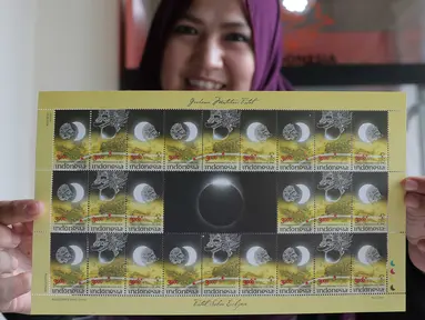 Petugas menunjukan perangko edisi Gerhana Matahari Total di Kantor Pos Indonesia, Jakarta, (25/2). Pos Indonesia (Persero) menerbitkan prangko edisi khusus tersebut dalam rangka menyambut peristiwa gerhana matahari total. (Liputan6.com/Angga Yuniar)