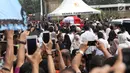 Warga berdesakan melihat prosesi pemakaman Presiden ke-3 RI BJ Habibie di TMP Kalibata, Jakarta, Kamis (12/9/2019). Upacara pemakaman Habibie dipimpin oleh Presiden Joko Widodo. (Liputan6.com/Helmi Fithriansyah)