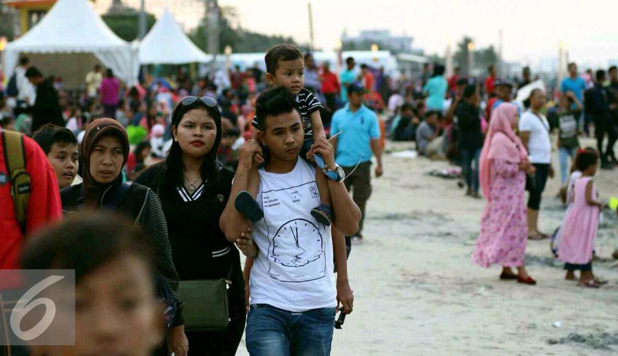 Sejumlah keluarga beserta anak-anaknya memadati kawasan pantai Ancol untuk menunggu pergantian tahun baru, Jakarta, Sabtu (31/12). (Liputan6.com/Angga Yuniar