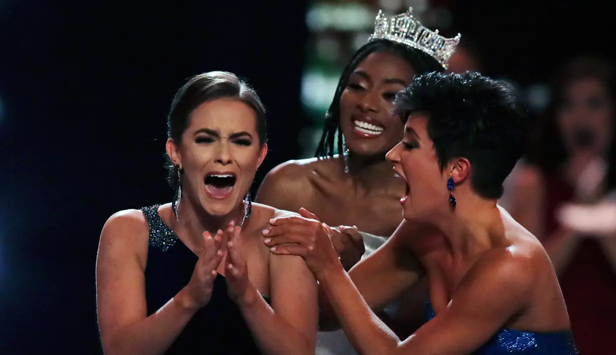 Ekspresi Miss Virginia Camille Schrier (kiri) saat memenangkan kompetisi Miss America di kasino Mohegan Sun, Uncasville, Connecticut, Amerika Serikat, Kamis (19/12/2019). Camille Schrier dihampiri oleh Miss America 2019  Nia Franklin (tengah) dan Miss Georgia Victoria Hill. (AP Photo/Charles Krupa)