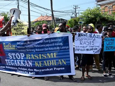 Ikatan Mahasiswa Pelajar dan Masyarakat Papua (IMMAPA) membawa spanduk saat berunjuk rasa di Lapangan Niti Mandala, Denpasar, Bali, Kamis (22/8/2019). Protes atas insiden yang terjadi di Asrama Papua di Surabaya ini diikuti oleh puluhan peserta. (SONNY TUMBELAKA/AFP)