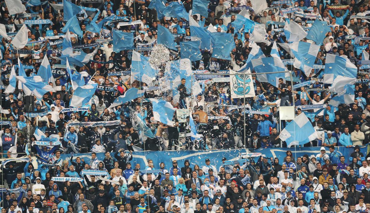 Aksi ribuan suporter Marseille memberikan dukungan kepada timnya saat melawan PSG  pada lanjutan Ligue 1 di  Velodrome Stadium, Marseille, (22/10/2017). PSG bermain imbang 2-2 melawan Marseille. (AFP/Valery Hache)