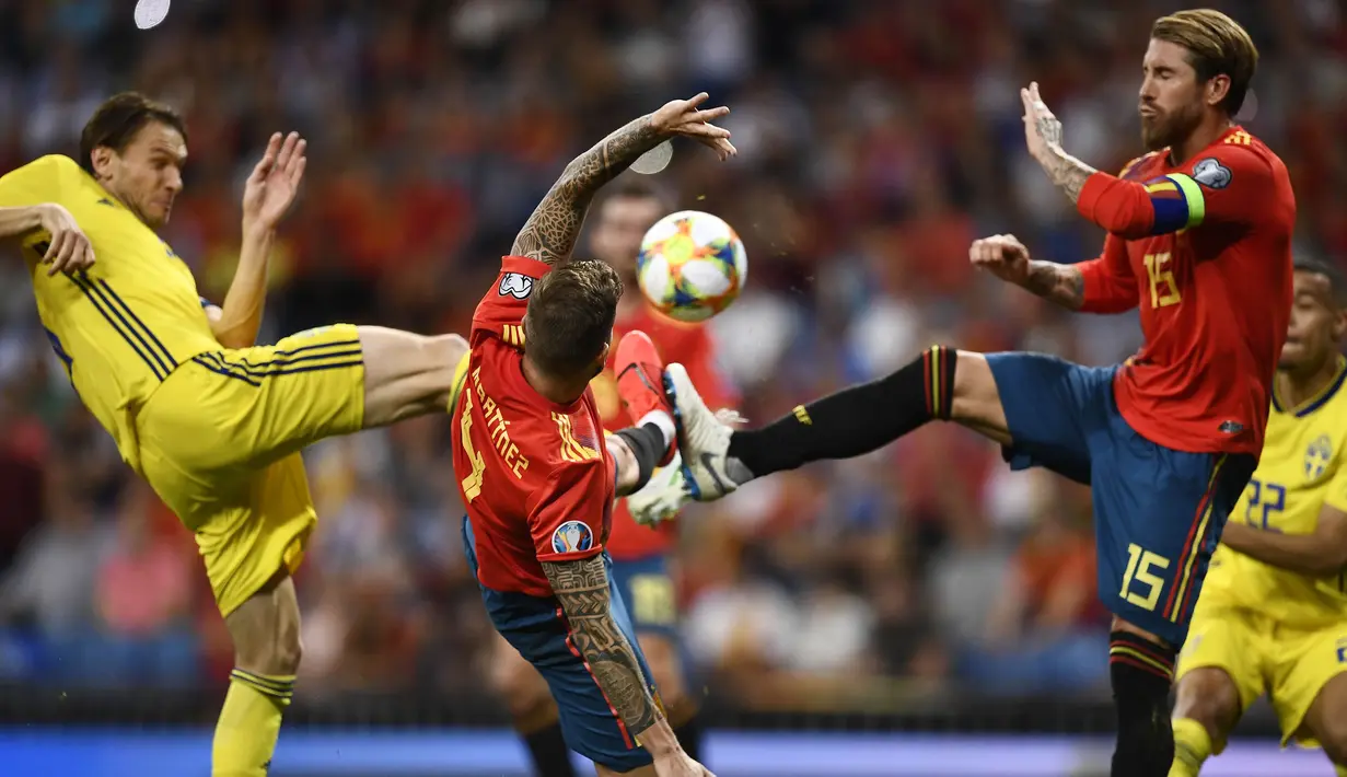 Striker Swedia, Marcus Berg, berebut bola dengan bek Spanyol, Sergio Ramos, pada laga Kualifikasi Piala Eropa 2020 di Stadion Santiago Bernabeu, Madrid, Senin (10/6). Spanyol menang 3-0 atas Swedia. (AFP/Oscar Del Pozo)