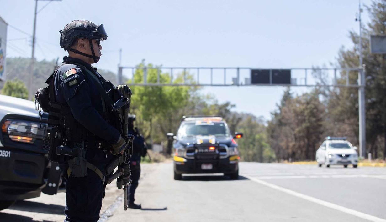 Petugas polisi melakukan pemeriksaan keamanan di Jalan Raya Morelia-Patzcuaro untuk mencegah pembakaran kendaraan dan blokade jalan di negara bagian Michoacan, Meksiko, pada 23 Februari 2026. (Enrique Castro/AFP)