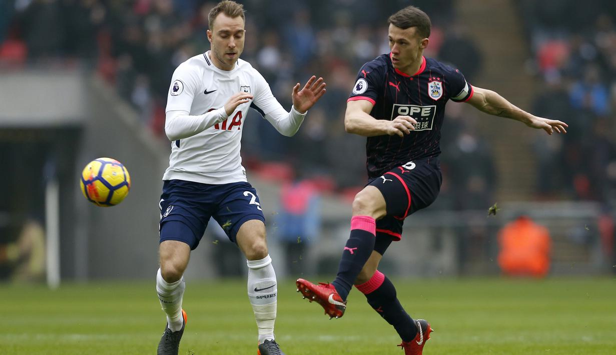 Pemain Tottenham Hotspur, Christian Eriksen (kiri) mengganggu sepakan pemain Huddersfield Town,  Jonathan Hogg pada laga Premier League di Wembley Stadium, London, (3/3/2018). Tottenham menang 2-0. (AFP/Ian Kington)
