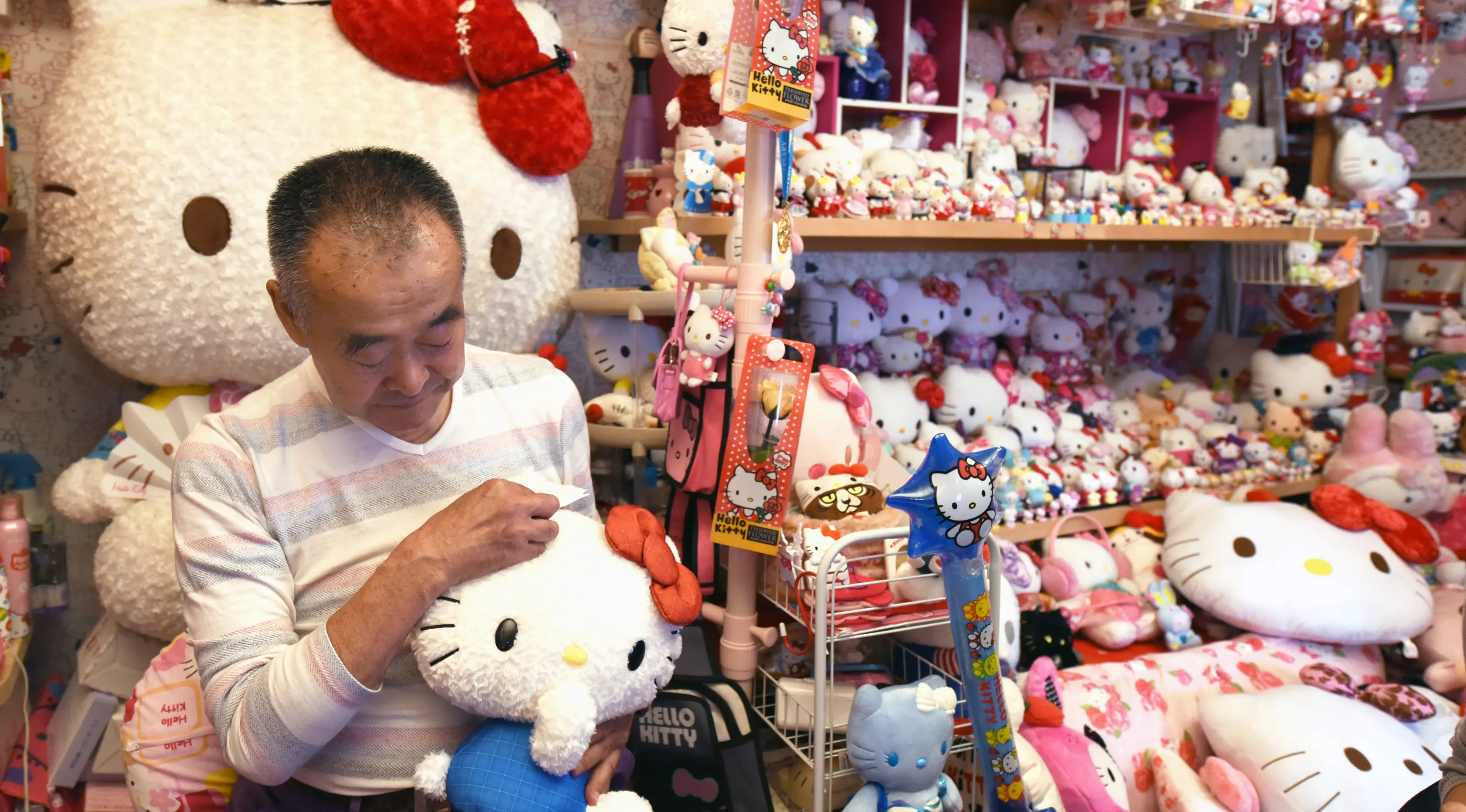 Masao Gunji memeluk boneka Hello Kitty di rumahnya di Yotsukaido, Chiba, Jepang (28/6). Masao Gunji juga mendapatkan rekor dari Guinness World Records karena koleksi Hello Kitty-nya yang sebanyak 5.169 barang. (AFP Photo/AFPBB/Yoko Akiyoshi)