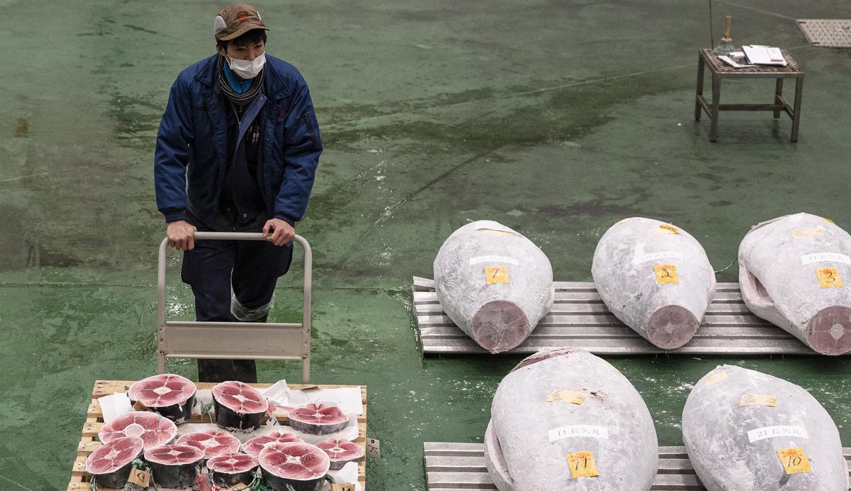 <p>Seorang pekerja mendorong gerobak tuna saat penjual grosir dan pembeli menghadiri lelang tuna pertama Tahun Baru di pasar ikan Toyosu di Tokyo (5/1/2023). Pada tahun ini, lelang tuna tertinggi terjual lebih dari USD 270.000. Hampir dua kali lipat dari harga tahun lalu. (AFP/Richard A. Brooks)</p>