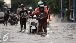 Pengendara mendorong motornya yang mogok akibat menerebos banjir di Jalan Kemang Raya, Jakarta, Jumat (11/11). Hujan deras yang mengguyur wilayah Jakarta menyebabkan banjir di kawasan Jalan Kemang Raya. (Liputan6.com/Yoppy Renato)