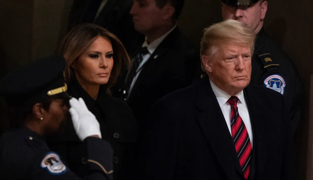 Presiden AS, Donald Trump bersama Melania Trump tiba untuk memberikan penghormatan terakhir kepada George HW Bush di Gedung Capitol, Washington, Senin (3/12). Bush senior meninggal dunia pada Jumat, 30 November 2018, di usia ke-94. (Alex Edelman/AFP)