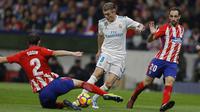 Gelandang Real Madrid, Toni Kroos, berusaha melewati bek Atletico Madrid, Diego Godin, pada laga La Liga di Stadion Metropolitano, Sabtu (18/11/2017). Derbi Madrid tersebut berakhir dengan skor 0-0. (AP/Francisco Seco)