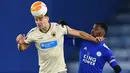 Bek AEK Athens, Ionut Nedelcearu bersaing dengan striker Leicester City, Kelechi Iheanacho pada matchday Grup G Liga Eropa UEFA di King Power Stadium, Jumat (11/12/2020) dinihari WIB. Leicester City memastikan diri keluar sebagai juara Grup G berkat kemenangan 2-0 atas AEK Athens. (Ben STANSALL/AFP)