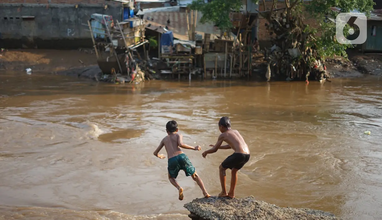 Anak-anak berenang di bantaran Sungai Ciliwung, Jakarta, Senin (5/10/2020). Derasnya aliran Sungai Ciliwung akibat hujan deras yang mengguyur Jakarta tidak menyurutkan kemauan anak-anak tersebut untuk tetap berenang, meski dapat membahayakan keselamatan mereka. (Liputan6.com/Immanuel Antonius)