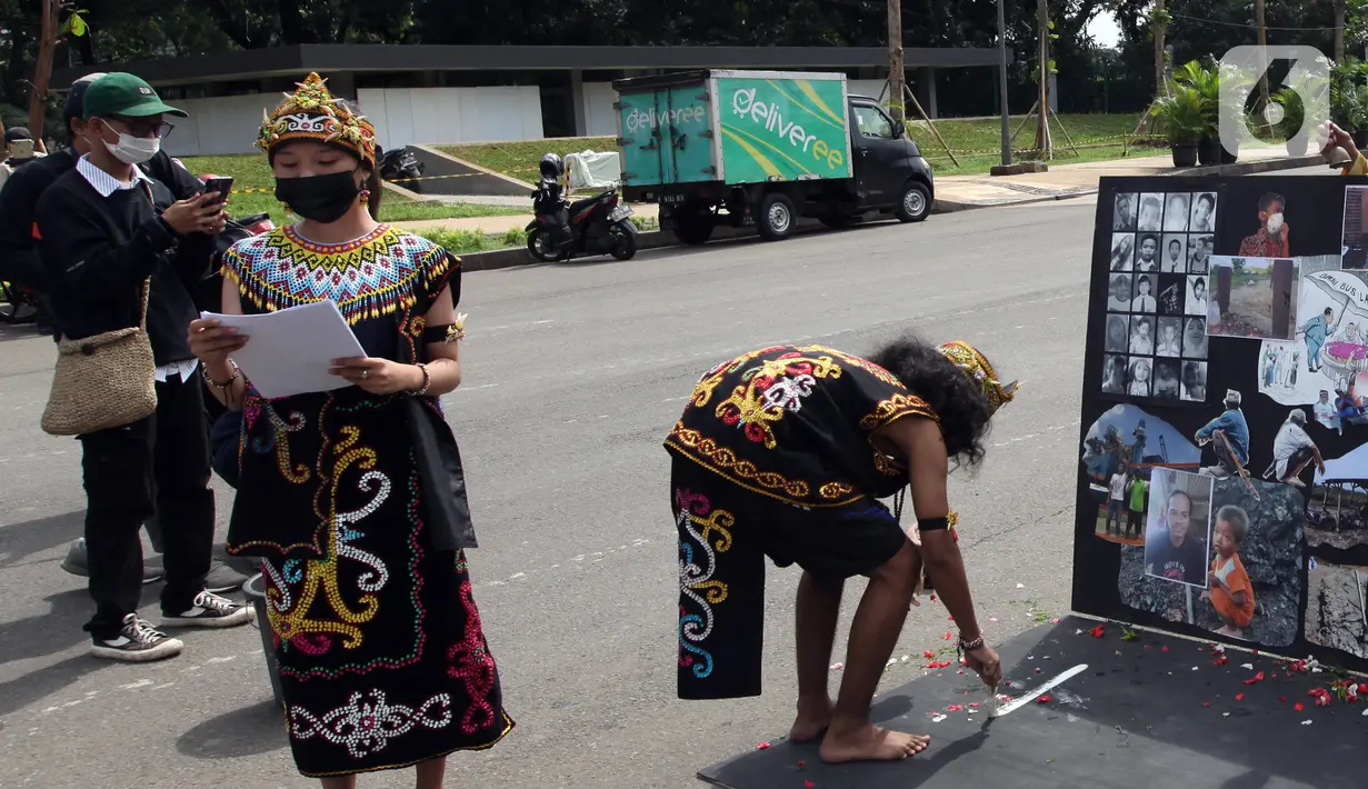 Demonstran melakukan aksi teatrikal saat unjuk rasa di kawasan Bundaran Patung Kuda Arjuna Wijaya, Jakarta, Senin (21/6/2021). Aksi yang dilakukan bertepatan dengan ulang tahun Presiden Joko Widodo ini sebagai bentuk kecaman dan penolakan terhadap revisi UU Minerba. (Liputan6.com/Angga Yuniar)