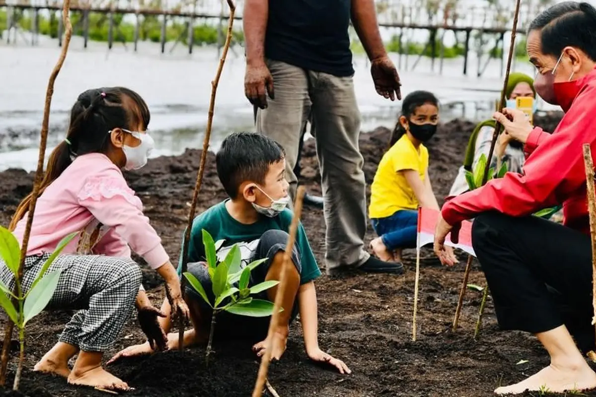 Presiden Jokowi menanam pohon mangrove bersama masyarakat di Pantai Wisata Raja Kecik Kabupaten Bengkalis, Riau, Selasa (28/9/2021).