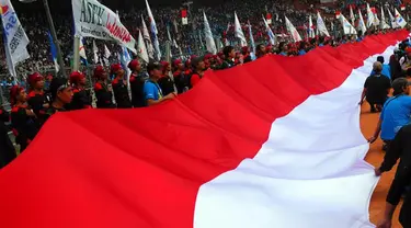 Di antara keriuhan teriakan buruh yang meneriakkan beragam tuntutan, sebuah bendera berukuran 100 meter persegi dibentangkan (Liputan6.com/Miftahul Hayat) 