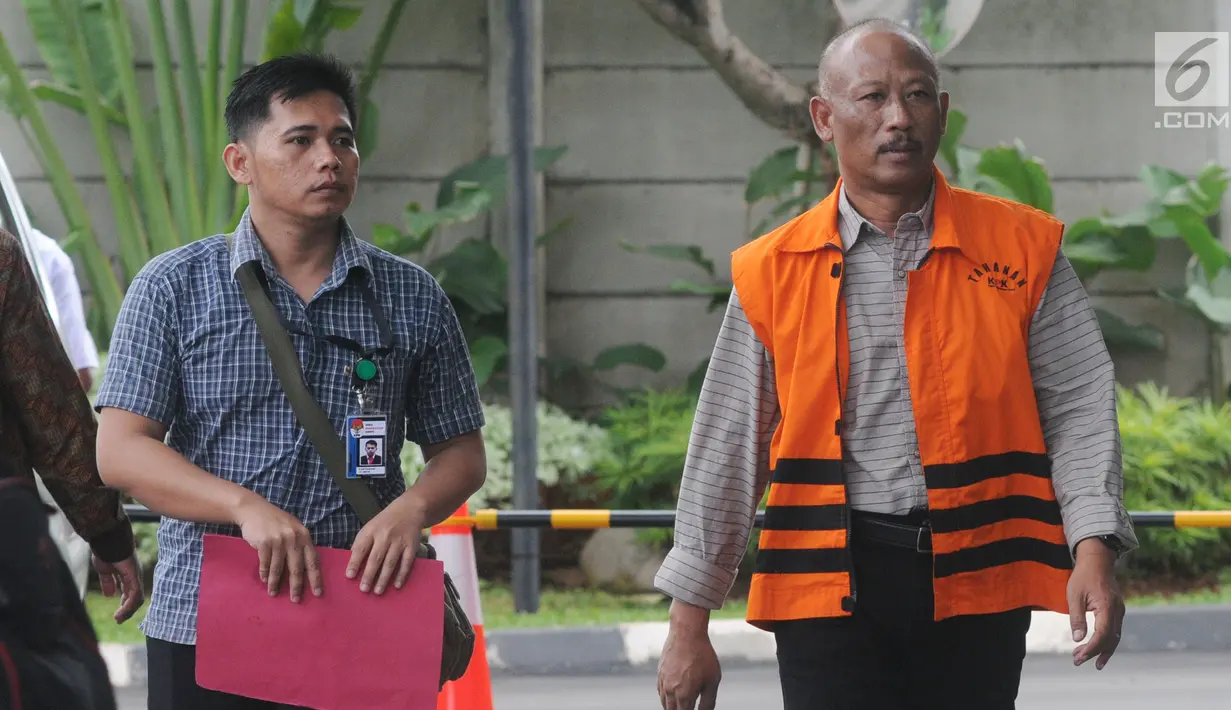 Kabid Pendidikan Dasar di Dinas Pendidikan di Kabupaten Klaten Bambang Teguh Satya dikawal petugas berjalan untuk menjalani pemeriksaan di gedung KPK, Jakarta, Jumat (21/12). Bambang diperiksa sebagai tersangka. (Merdeka.com/Dwi Narwoko)