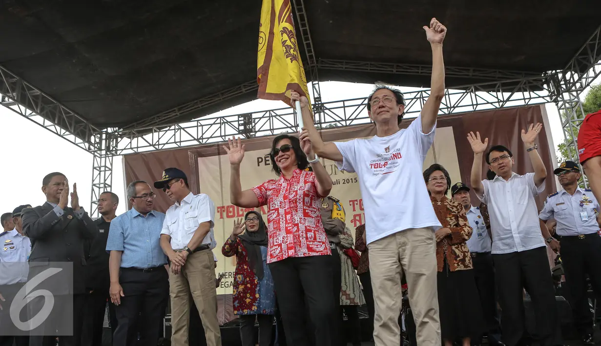 Presiden Direktur Sido Muncul, Irwan Hidayat memegang bendera melepas secara simbolis para pemudik ke berbagai daerah di Jakarta, Minggu (12/7/2015). 320 unit bus disiapkan untuk 20 ribu pemudik ke berbagai jurusan. (Liputan6.com/Faizal Fanani)