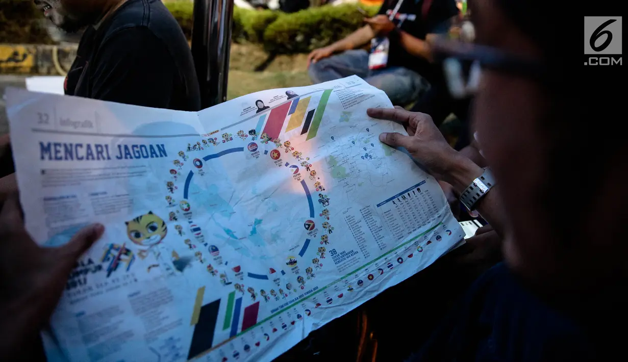 Seorang pria membaca Surat kabar Malaysia, Metro Ahad, saat perhelatan  SEA Games 2017 di Kuala Lumpur, Minggu (20/8). Koran tersebutmemasang bendera Indonesia terbalik, yaitu putih di bagian atas dan bawah berwarna merah. (Liputan6.com/Faizal Fanani)