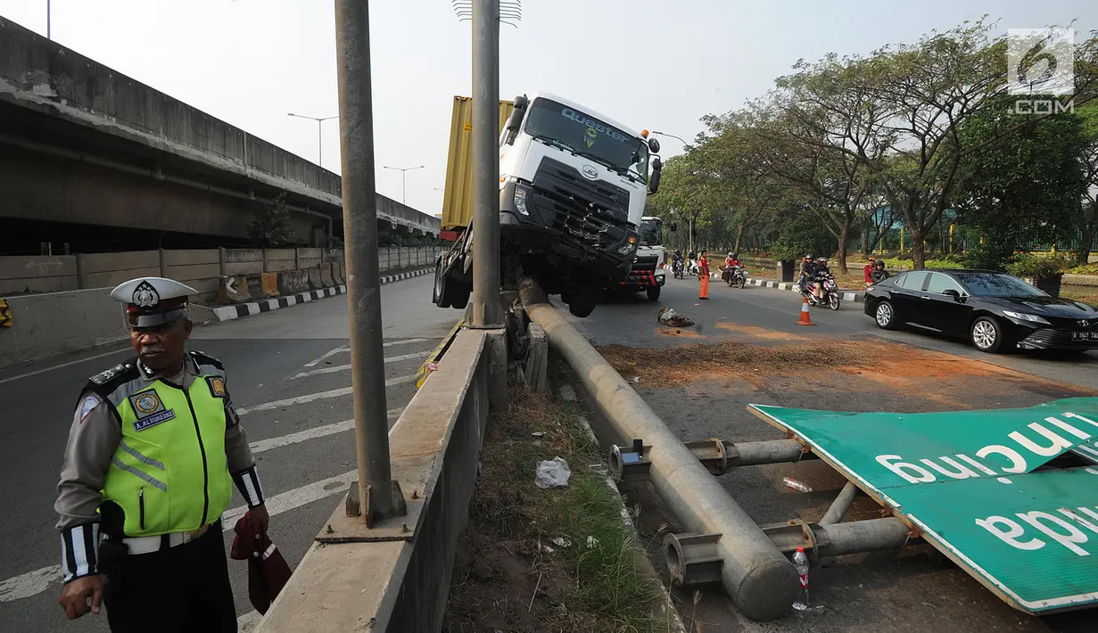 Petugas polisi berada di lokasi kecelakaan kendaraan berat kontainer yang menabrak jalur pembatas pintu masuk tol akses Tanjung Priok di Jalan Raya Cilincing, Jakarta Utara, Sabtu (17/8/2019). (merdeka.com/Arie Basuki)