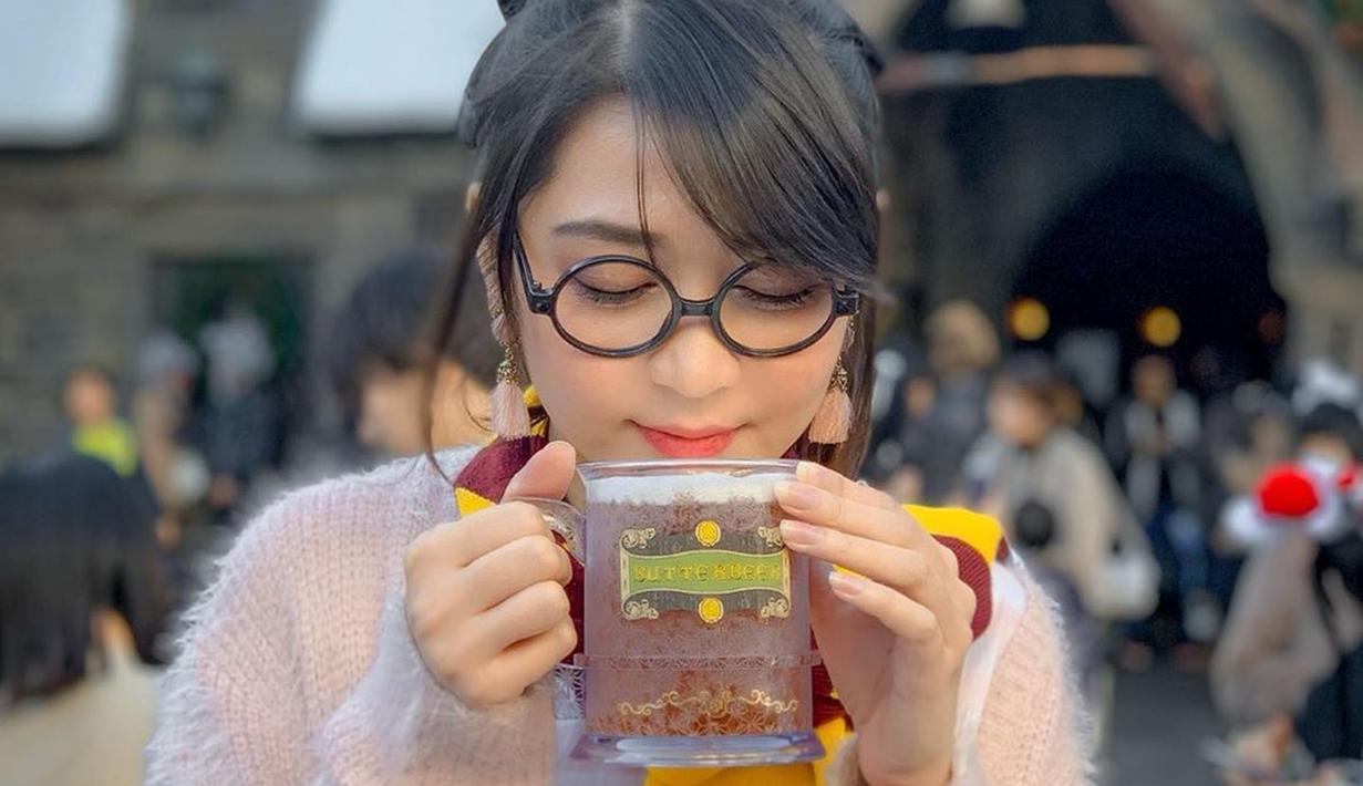 Eks JKT48 tim J ini gaya penampilannya bisa terlihat imut saat memakai kacamata. Seperti momen menikmati minuman panas di Universal Studios Japan. Kacamata yang dipakai Ve begitu pas dengan bentuk wajahnya. (Liputan6.com/IG/@jcvrnd19)