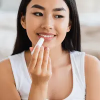 llustrasi menggunakan lip balm/copyright shutterstock/Prostock studio