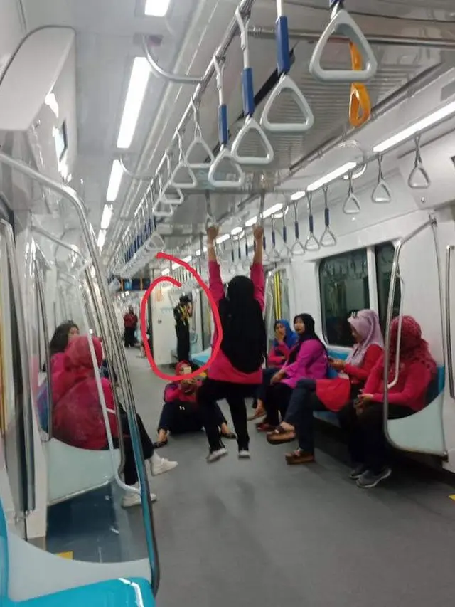 Penumpang MRT bergelantungan di dalam kereta.