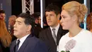Pesepakbola legendaris Argentina, Diego Maradona mengandeng tangan kekasihnya, Rocio Oliva saat tiba menghadiri The Best FIFA Football Awards 2017 di London, (23/10). Rocio Oliva merupakan mantan pemain sepak bola wanita. (AP Photo/Alastair Grant)