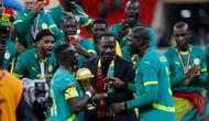 Pelatih kepala Senegal, Pape Thiaw (C), dan tim merayakan kemenangan dengan trofi setelah memenangkan pertandingan final Piala Afrika (CAN) 2025 melawan Maroko di Stadion Pangeran Moulay Abdellah di Rabat, Senin (19-1-2026) dini hari WIB. (Abdel Majid BZIOUAT/AFP)