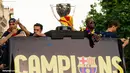 Beberapa pemain Barcelona berdiri di atas bus berikut dengan trophy La Liga.