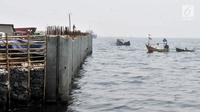 Perahu nelayan melintas di dekat proyek tanggul laut raksasa atau giant sea wall di Cilincing, Jakarta, Kamis (15/3). Tanggul laut raksasa ini diharapkan mampu mencegah rob yang kerap melanda pesisir Jakarta. (Merdeka.com/Iqbal Nugroho)