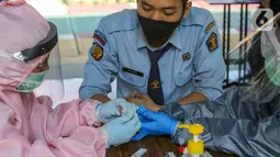 Tenaga medis mengambil sampel darah Pegawai Lapas Kemenkumham menjalani rapid test di Lembaga Pembinaan Khusus Anak (LPKA) Klas I Tangerang, Banten, Sabtu (30/5/2020). Hasil rapid test Covid-19 yang diikuti 87 pegawai diserahkan ke Kanwil Kemenkumham Banten. (Liputan6.com/Fery Pradolo)