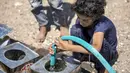 Dengan pasokan air yang sangat terbatas, banyak orang tua yang membutuhkan bantuan anak-anak mereka untuk mendapatkannya. (AHMAD AL-BASHA / AFP)