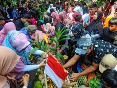 Warga membawa hasil pertanian saat acara budaya sedekah bumi di Lembur Sawah, Mulyaharja, Bogor, Jawa Barat, Minggu (23/7/2023). (merdeka.com/Arie Basuki)