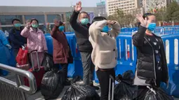 Pasien yang telah sembuh melambaikan tangan saat berjalan keluar dari rumah sakit sementara Wuchang di Wuhan, 10 Maret 2020. Dua rumah sakit sementara terakhir di Wuhan ditutup pada hari itu yang sekaligus menandai penutupan seluruh 16 rumah sakit sementara di kota tersebut. (Xinhua/Xiao Yijiu)