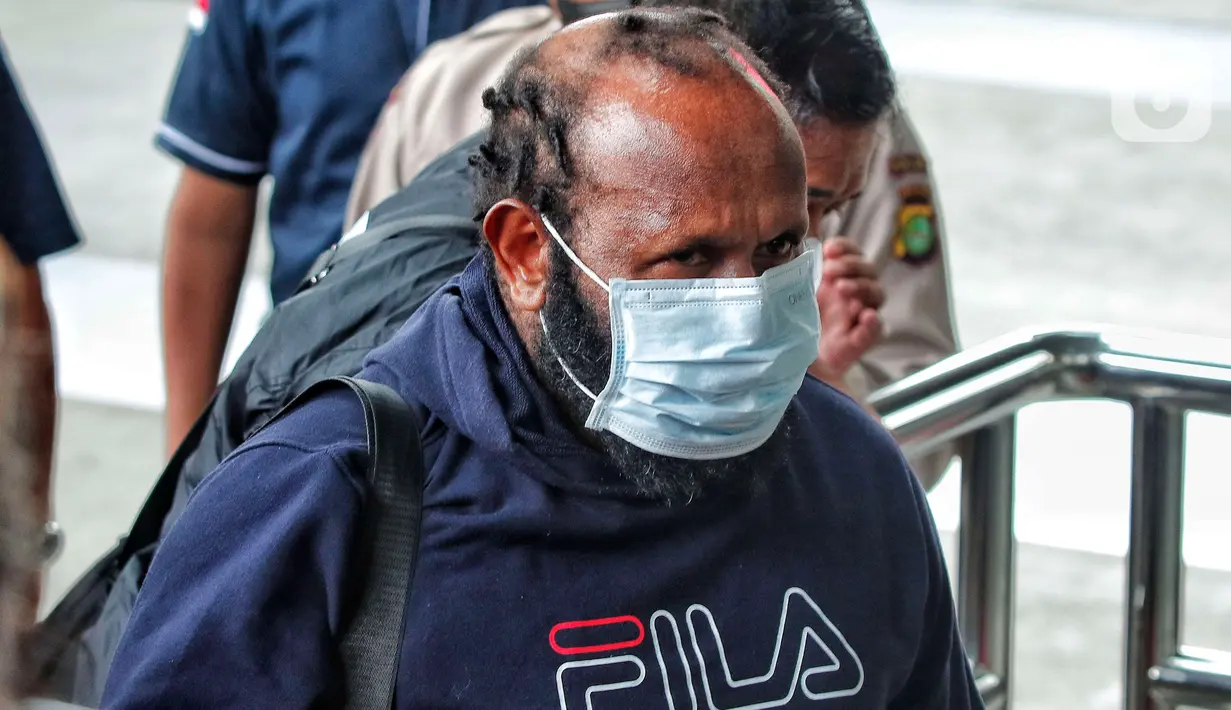Tersangka kasus dugaan suap Bupati Mamberamo Tengah nonaktif, Ricky Ham Pagawak (RHP), berjalan memasuki gedung Merah Putih KPK, Jakarta, Senin (20/2/2023). Ricky Ham Pagawak tiba di lobi gedung KPK pukul 12.57 WIB. Ia turun dari mobil penyidik dengan dijaga sejumlah petugas KPK. (Liputan6.com/Angga Yuniar)