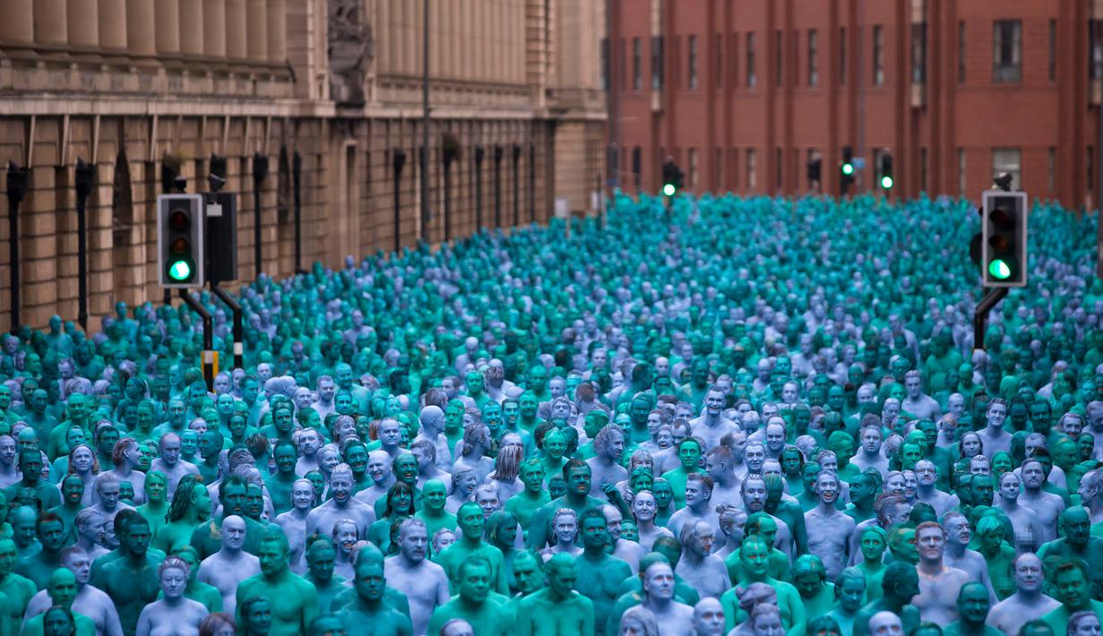 Ribuan orang dengan tubuh di cat berwarna biru bertelanjang bulat saat menjadi model sebuah seni berjudul "Sea of Hull" karya Spencer Tunick asal Amerika Serikat di pusat Kota Hull, Inggris, Sabtu (9/7). (AFP Photo/Jon Super)