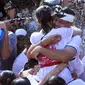 Dua pasangan remaja pria dan wanita saling berpelukan saat festival Omed-omedan di Bali, Kamis (29/3). Festival yang dilakukan sehari setelah Hari Raya Nyepi tersebut digelar untuk memupuk persaudaraan pemuda dan pemudi desa. (AP Photo/Firdia Lisnawati)