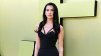 Dua Lipa, penyanyi sekaligus penulis lagu asal Inggris berpose saat tiba untuk peragaan busana Versace Fall/Winter 2023 di Pacific Design Center, West Hollywood, California, Amerika Serikat, 9 Maret 2023. Dua Lipa menata rambut hitamnya menjadi gelombang romantis dengan belahan samping yang dramatis. (Jon Kopaloff/Getty Images/AFP)
