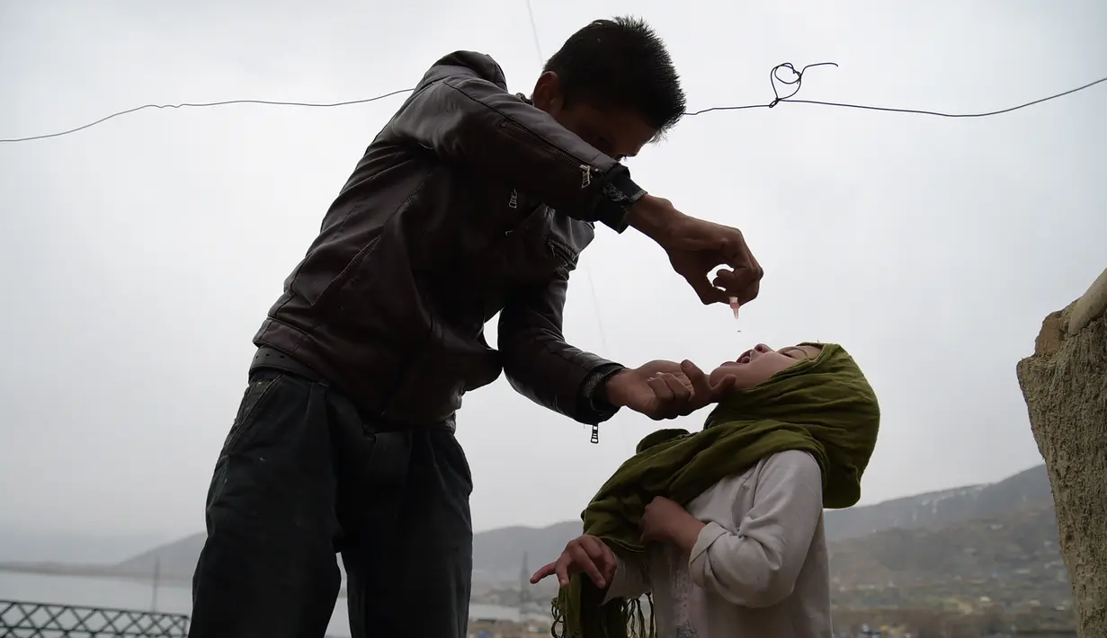 Petugas memberikan vaksin polio kepada seorang anak di Kabul, Afghanistan, Senin (28/2). Di masa lalu, kelompok militan menolak kampanye polio karena dianggap sebagai persekongkolan untuk memandulkan Muslim. (AFP PHOTO / SHAH Marai)