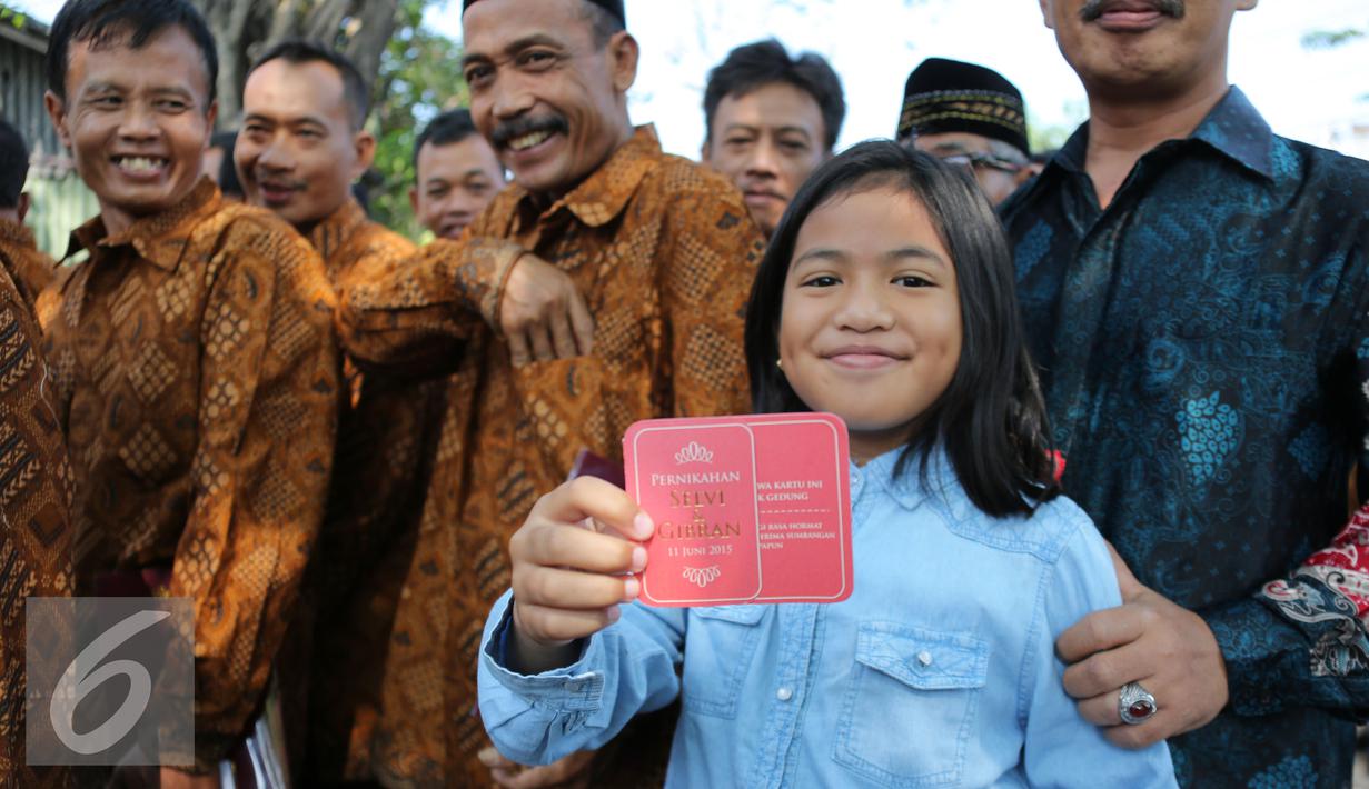 Seorang anak memperlihatkan undangan resepsi pernikahan Gibran Rakabuming putra sulung Presiden Joko Widodo dan Selvi Ananda di Gedung Graha Saba Buana, Solo, Jawa Tengah, Kamis (11/6/2015). (Liputan6.com/Faizal Fanani)