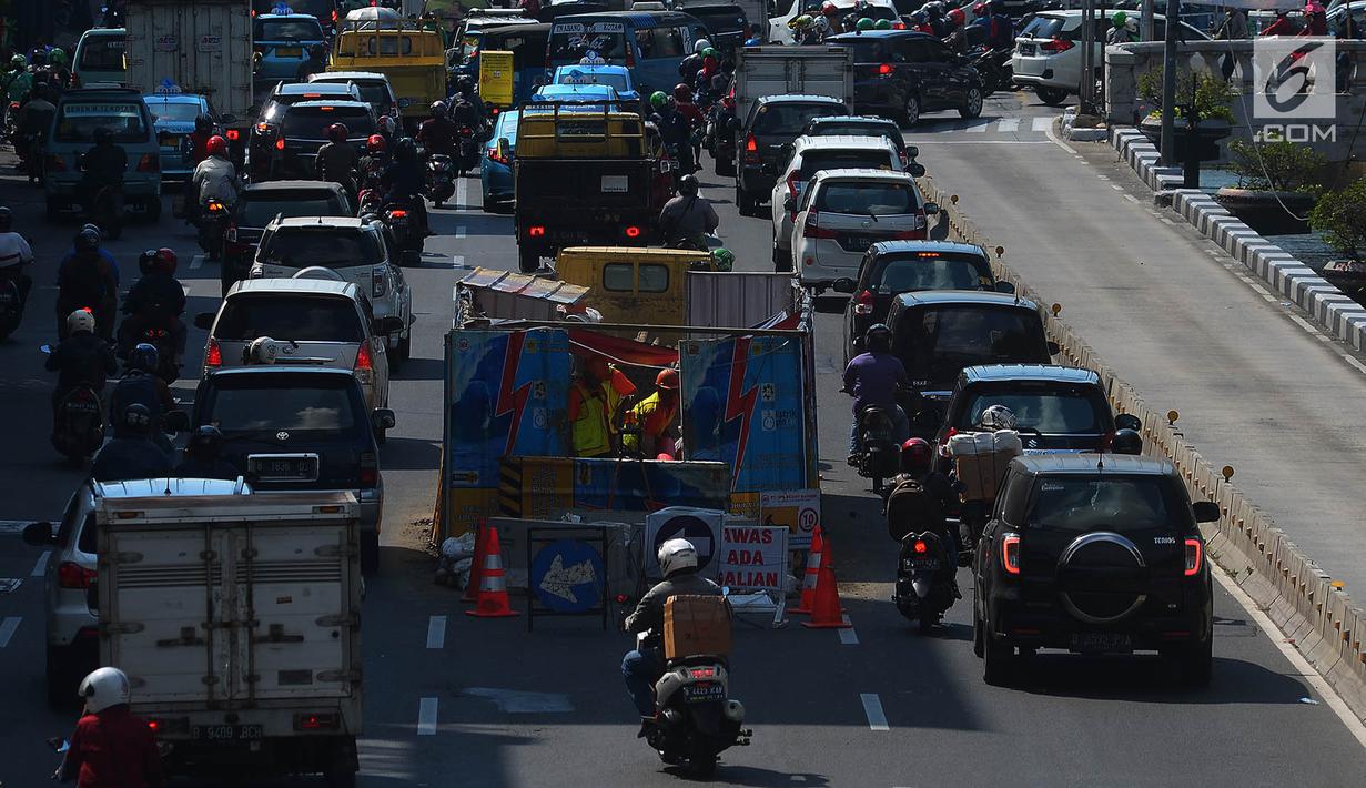 Sejumlah kendaraan melintas di dekat galian kabel yang berada di tengah jalan Gajah Mada, Jakarta, Sabtu (12/5). Galian kabel instalasi listrik yang berada di tengah jalan ini membuat arus lalu lintas sedikit tersendat. (Merdeka.com/Imam Buhori)
